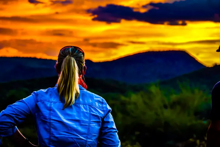 a person standing in front of a sunset