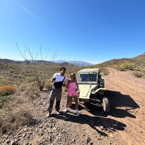 Guests posing on top of a Tomcar at sunset in the Sonoran Desert during a Scottsdale & Phoenix ATV tour with Desert Wolf Tours — no helmets or goggles.