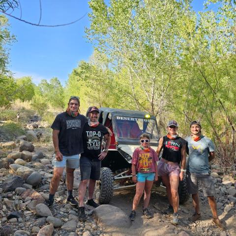 Riders tackling a sandy Sonoran Desert wash during a Scottsdale & Phoenix ATV tour with Desert Wolf Tours — Tomcar UTV, no helmets or goggles, full-air experience.