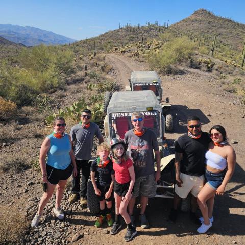 Guests posing near a saguaro cactus on a Scottsdale & Phoenix Tomcar ATV tour with Desert Wolf Tours in the Sonoran Desert — open-air ride, no helmets or goggles