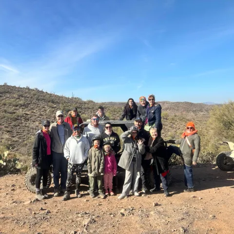 Guests posing beside a Tomcar on a Scottsdale and Phoenix ATV tour in the Sonoran Desert with Desert Wolf Tours, enjoying a no-helmet, open-air adventure.