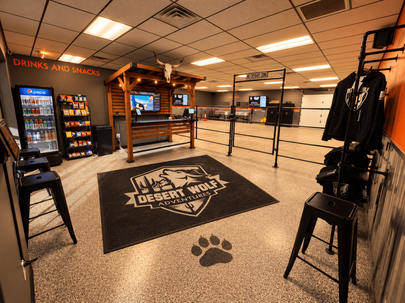 Interior of Desert Wolf Tours - Wolf Den Phoenix check in and departure facility; climate controlled, clean restrooms, snacks, beverages, Desert Wolf swag, electronic check in counter, and a logo mat.